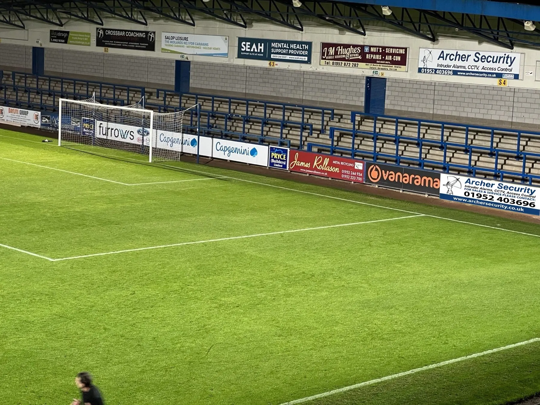 Archer Security advertising boards at a floodlit football ground